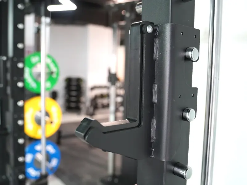 Close-up of a steel J-cup attachment mounted on a commercial power rack upright.