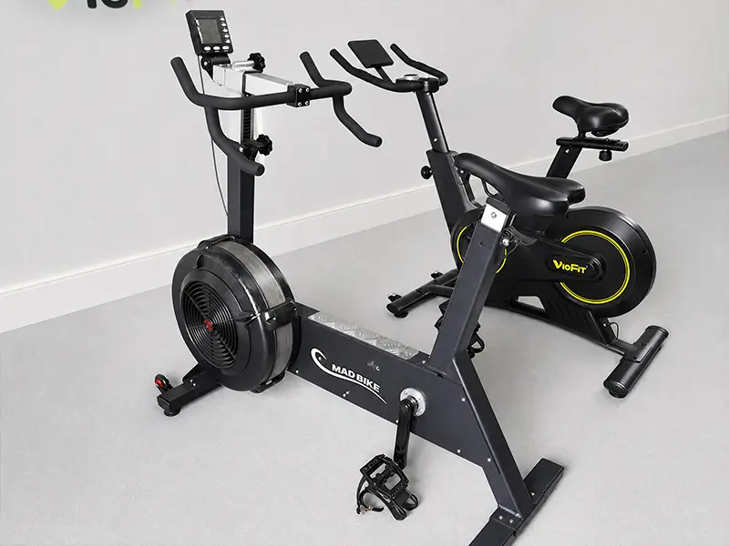 Stationary exercise bikes with different handlebar designs and display consoles in the VIGFIT showroom