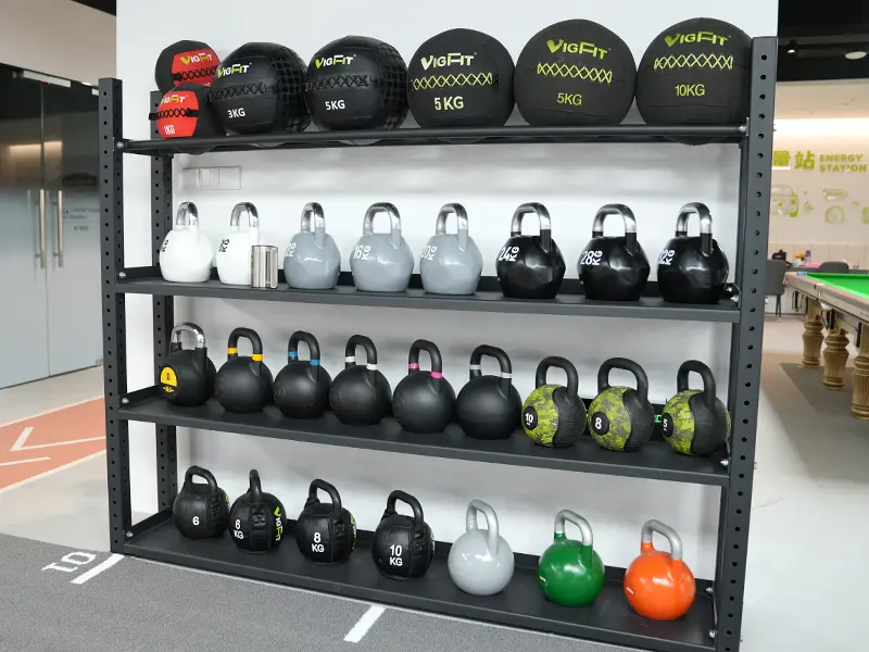 VIGFIT wall balls and kettlebells in different weights displayed on a gym storage rack