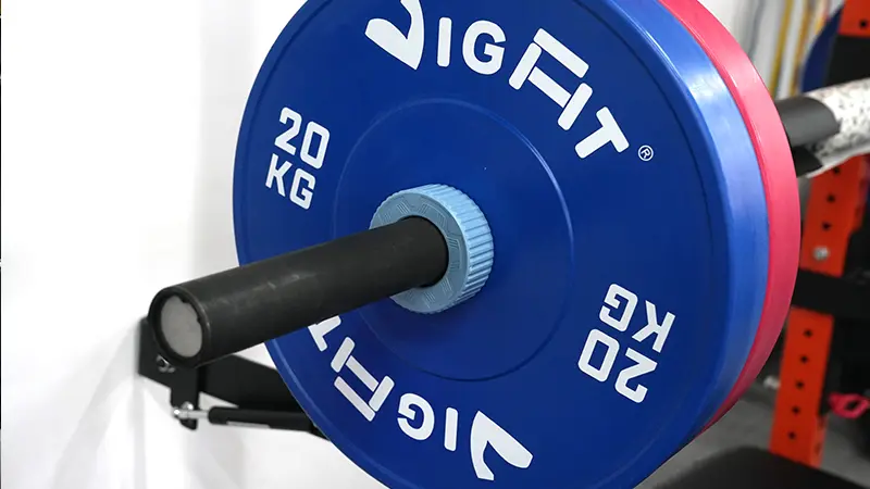 A close-up of premium VIGFIT polyurethane bumper plates on an Olympic barbell