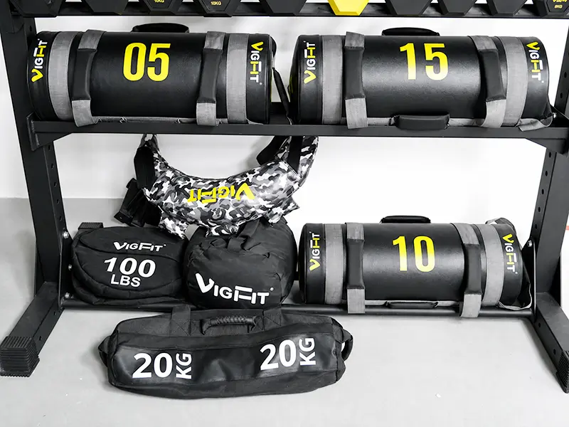 VIGFIT power bags and sandbags in different shapes and weights displayed on a storage rack
