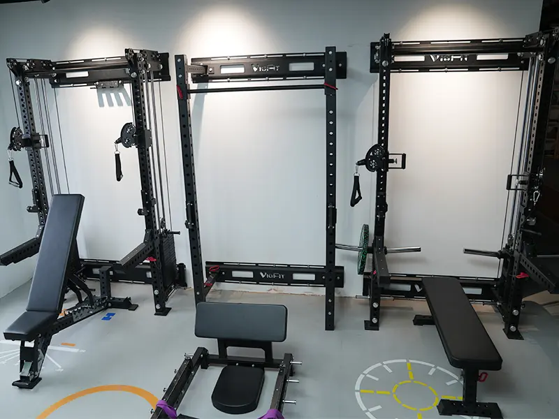 VIGFIT power racks and functional trainers displayed with adjustable weight benches in a showroom.