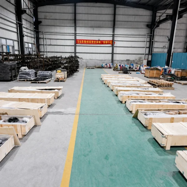 Fitness equipment components packed in wooden crates inside a factory warehouse